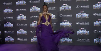 Lupita Nyong'O menghadiri momen purple carpet dalam premier Black Panther di Hollywood, California, dengan gaun berwarna senada. (VALERIE MACON / AFP)