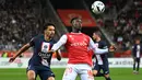 Bek Paris Saint-Germain (PSG) Marquinhos berebut bola dengan pemain depan Reims, Folarin Balogun dalam pertandingan pekan ke-10 Liga Prancis di Stade Auguste-Delaune II, Minggu (9/10/2022) dini hari WIB. Pertandingan berakhir dengan serangkaian pelanggaran karena laga berjalan panas. (AP Photo/Michel Euler)