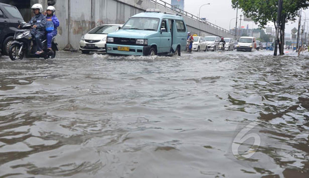 Sejumlah kendaraan bermotor saat melintasi genangan air di Jalan Pramuka, Jakarta. (Liputan6.com/Andrian M Tunay)