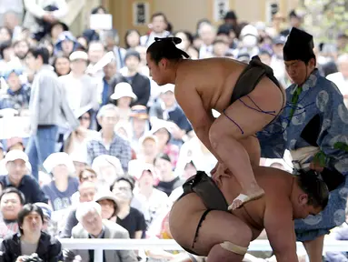 Aksi dua pegulat sumo saat bertarung dalam turnamen Sumo, Honozumo di Kuil Yasukuni, Tokyo, Senin (18/4). Selain menjadi ajang kejuaraan olahraga tradisional jepang, kejuaraan tahunan itu juga menjadi daya tarik wisata. (REUTERS/Yuya Shino)