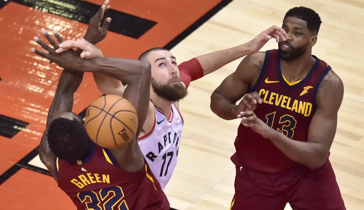 Pemain Raptors, Jonas Valanciunas (tengah) mencoa melewati adangan dua pemain Cavaliers  pada laga NBA basketball playoffs Eastern Conference semifinal di Air Canada Centre, (1/2/2018). Cavaliers menang 113-112. (Frank Gunn/The Canadian Press via AP)