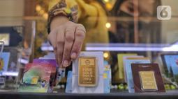 Pegawai menunjukkan emas batangan yang tersusun dalam etalase di Galeri 24, Jakarta, Selasa (13/9/2022). Harga emas Antam hari ini naik Rp 3.000 dibandingkan perdagangan sehari sebelumnya. (Liputan6.com/Angga Yuniar)