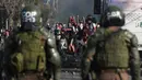 Demonstran saat bentrok dengan polisi di tengah pandemi virus corona Covid-19 selama penguncian wilayah (lockdown) di lingkungan miskin di Santiago, Chili, (18/5/2020). Demonstrasi tersebut berujung kerusuhan. (AP Photo/Esteban Felix)