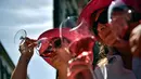 Para wanita mencicipi anggur mawar Spanyol untuk mempromosikan minuman tersebut di Pamplona, Spanyol, Sabtu (19/5). (AP Photo/Alvaro Barrientos)