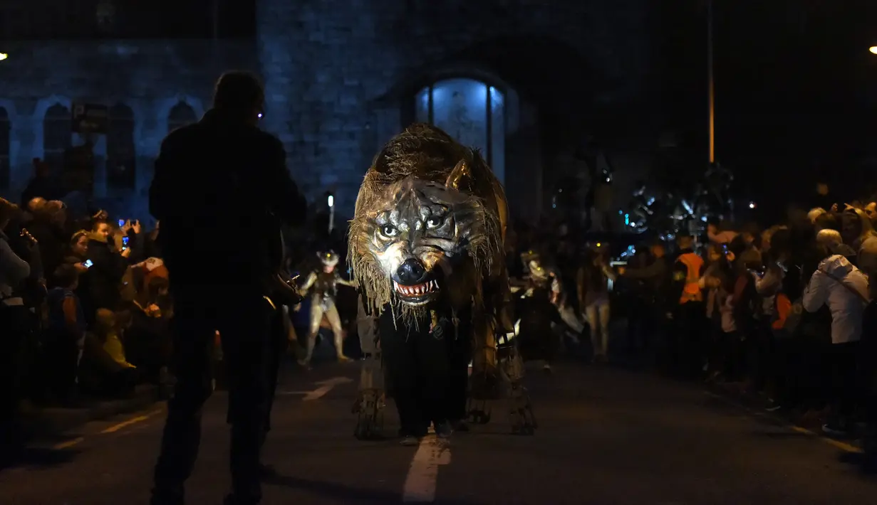 Sejumlah warga menyaksikan boneka serigala selama Parade Halloween di Irlandia (30/10). Parade ini untuk merayakan hari Halloween yang jatuh pada tanggal 31 Oktober. (REUTERS/Lucy Nicholson)