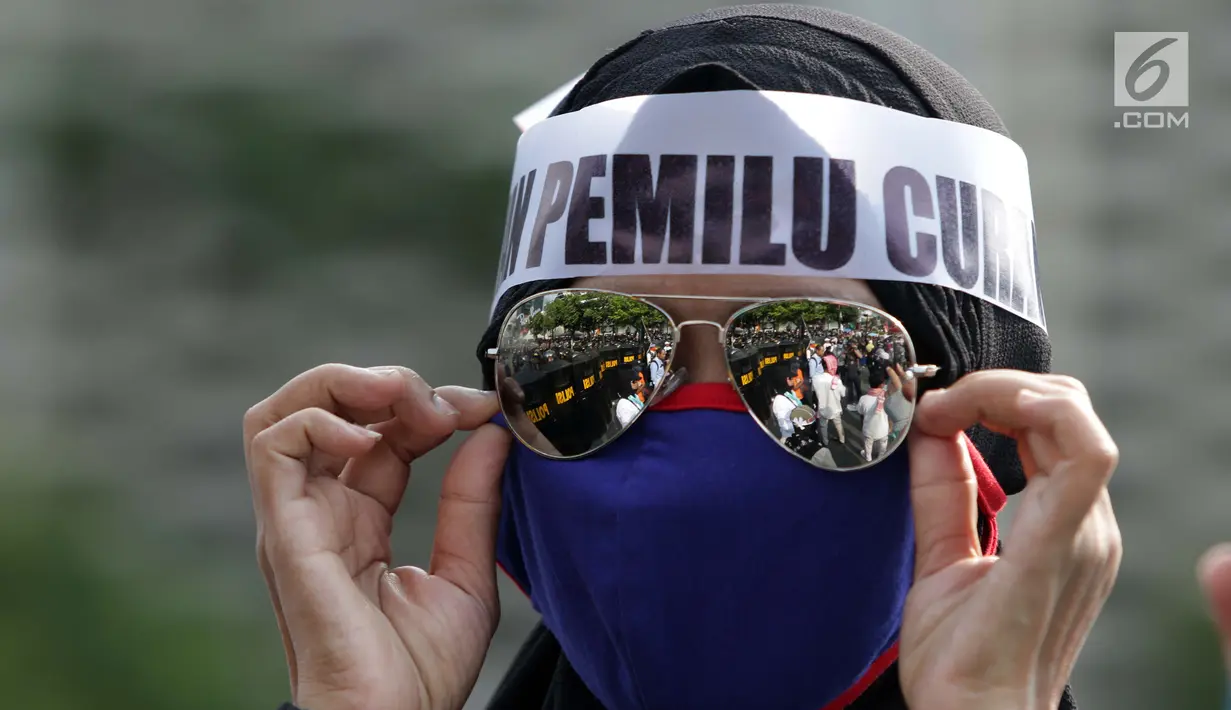 Salah satu peserta aksi massa Gerakan Nasional Kedaulatan Rakyat saat melakukan unjuk rasa di depan Gedung Bawaslu, Jakarta, Selasa (21/5). Mereka menolak hasil Pemilu 2019 yang dinilai banyak terdapat kecurangan. (Liputan6.com/Helmi Fithriansyah)