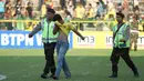 Polisi membantu suporter yang terluka saat terjadi keributan antar suporter dalam laga Gresik United melawan PS TNI di Stadion Tri Dharma, Gresik, Minggu (22/5/2016). (Bola.com/Fahrizal Arnas)