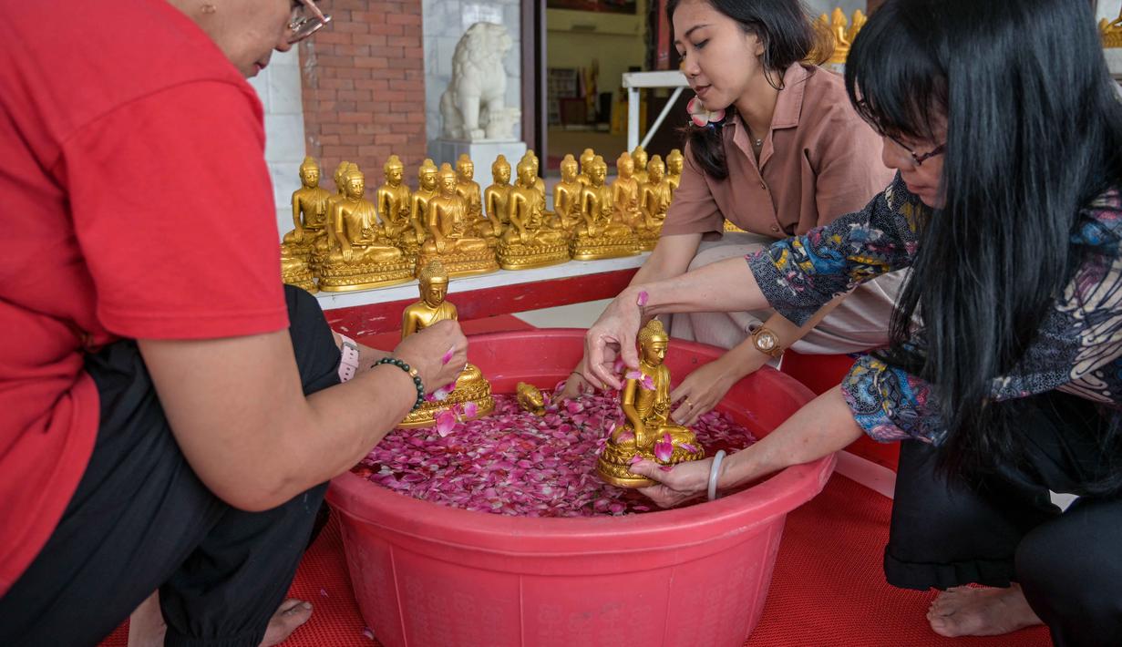Ritual ini tidak sekadar membersihkan debu secara fisik, melainkan memiliki makna spiritual yang mendalam. Tampak dalam foto, warga membersihkan patung Buddha dalam persiapan perayaan Tahun Baru Imlek 2577 Kongzili di Vihara Buddhayana, Surabaya, Jawa Timur pada Senin 9 Februari 2026. (JUNI KRISWANTO/AFP)