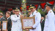 Mendagri Tito Karnavian memberikan penghargaan kepada Pj Gubernur Jawa Tengah Nana Sudjana pada Upacara Peringatan Hari Otonomi Daerah ke-28 di Balai Kota Surabaya, Kamis, 25 April 2024.
