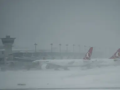 Sejumlah pesawat terparkir di Bandara Ataturk akibat landasan ditutupi salju tebal yang melumpuhkan Kota Istanbul, Turki, Sabtu (7/1). Badai salju dahsyat melumpuhkan aktivitas warga dengan ratusan jadwal penerbangan tertunda. (OZAN KOSE/AFP)