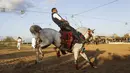 Pria Palestina berusaha bertahan saat menunggangi kudanya pada ajang Arabian Horse Show di Kota Gaza, Palestina (3/3). (AFP Photo / Mohammed Abed)