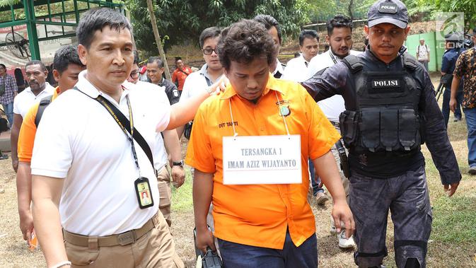 Tersangka IAW menjalani proses rekonstruksi Lapangan Tembak Senayan, Jakarta, Jumat (19/10). IAW menjalani 25 adegan rekonstruksi terkait dugaan enam peluru yang tertembak ke enam ruangan di Gedung DPR RI. (Liputan6.com/Immanuel Antonius)