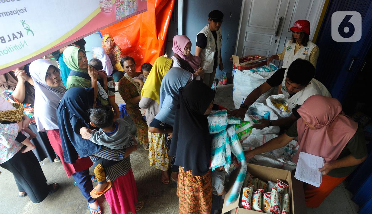 Warga antre mendapatkan pampers dan biskuit bagi anak-anak di Posko pengungsian Mangunkerta, Cianjur, Jumat (23/12/2022). Lebih dari sebulan sejak musibah gempa bumi 5,2 SR sejumlah warga masih tinggal di pengungsian dengan bantuan kebutuhan hidup dari para donatur. (merdeka.com/Arie Basuki)