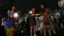 Warga menyalakan kembang api saat car free night pada malam pergantian tahun di Jalan MH Thamrin, Jakarta, Senin (31/12). Hujan yang mengguyur Jakarta sejak siang tidak menyurutkan antusias warga menikmati car free night. (Liputan6.com/Angga Yuniar)