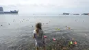 Seorang anak perempuan melihat-lihat perahu kertas yang diluncurkan saat perayaan 69 tahun akhir Perang Dunia II di Timur Jauh Vladivostok, Rusia, (2/9/2014). (REUTERS/Yuri Maltsev)