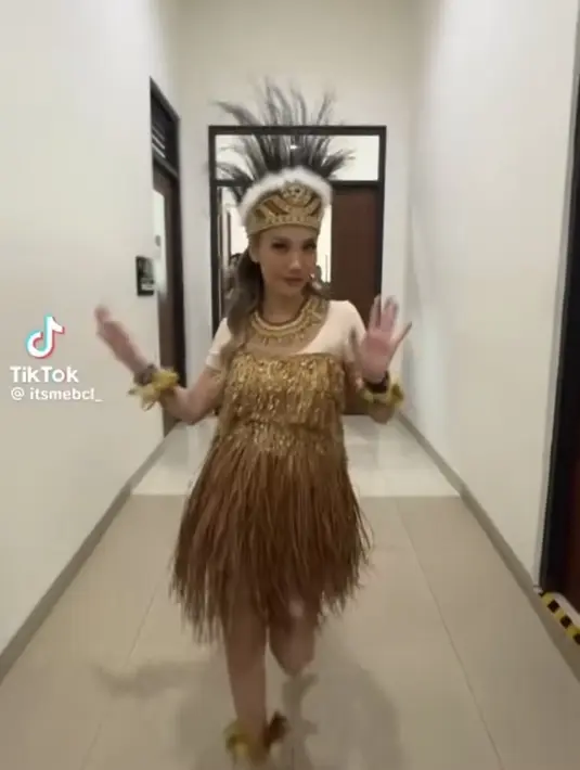 BCL tampil mengenakan baju adat Papua dengan atasan manset lengan pendek warna kulit dipadukan baju khas perempuan Papua dengan rumbai-rumbai warna coklat dari atasan hingga roknya. [@itsmebcl]