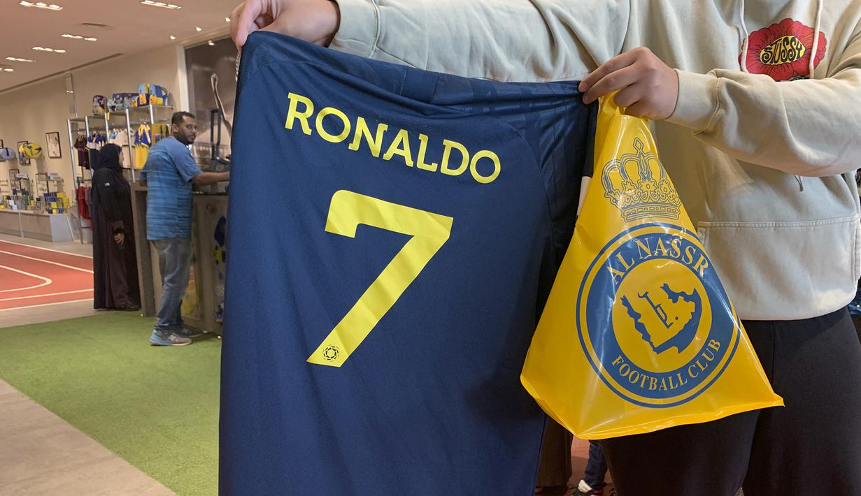 Kepastian bergabungnya Cristiano Ronaldo pada 31 Desember 2022 bersama klub papan atas Arab Saudi, Al Nassr langsung berpengaruh signifikan dari sisi bisnis. Para fans Al Aalami, julukan bagi Al Nassr, berbondong-bondong mengunjungi toko resmi pernak-pernik klub Al Nassr di Riyadh untuk berburu jersey bernomor punggung 7 bertuliskan "Ronaldo". (AFP/Fayez Nureldine)