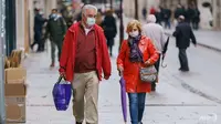 Orang-orang yang memakai masker wajah berjalan di Burgos, Spanyol utara, pada 21 Oktober 2020. (Foto: AFP / Cesar Manso)