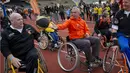 Johan Cruyff menaiki kursi roda bersama penyandang disabilitas pada acara Cruyff Foundation di Olympic Stadion, Amsterdam,  Rabu (14/9/2011). Legenda sepak bola itu merupakan sosok yang sangat peduli terhadap kaum disabilitas. (AFP/Marcel Antonisse)