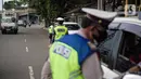Polisi memeriksa surat-surat pengendara yang memasuki jalur khusus Transjakarta saat Operasi Zebra Jaya 2021 di kawasan Jalan Gatot Subroto, Jakarta, Selasa (16/11/2021). Polda Metro Jaya menggelar Operasi Zebra Jaya 2021 pada 15-24 November. (Liputan6.com/Faizal Fanani)