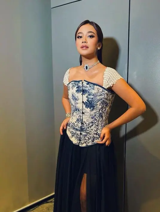 Jodie juga tampil dengan korset bermotif biru dengan aksen lengan putih pendek dipadukan slit skirt navy dari Howard Laurent Couture. [@brisiajodie96]