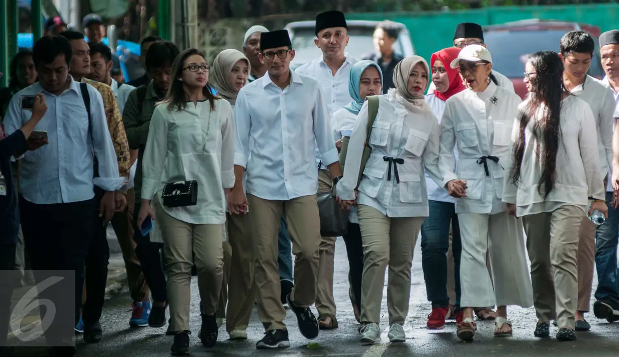 Cawagub DKI Sandiaga Uno ditemani istri serta kedua anaknya berjalan menuju TPS 01 Kelurahan Selong, Jalan Daha 4, Kebayoran Baru, Jakarta Selatan, Rabu (15/2). Sandiaga Uno juga datang ke TPS bersama kedua orang tuanya. (Liputan6.com/Gempur M Surya)