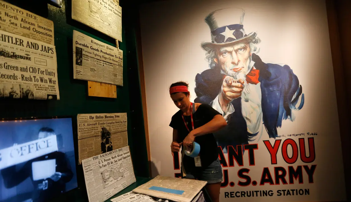 Seorang pekerja memasang koran untuk pameran "Salute to the Home Front" di Museum Nasional Perang Dunia II di New Orleans (5/6). Pameran ini menceritakan kisah yang berhubungan dengan Perang Dunia II. (AP Photo/Gerald Herbert)