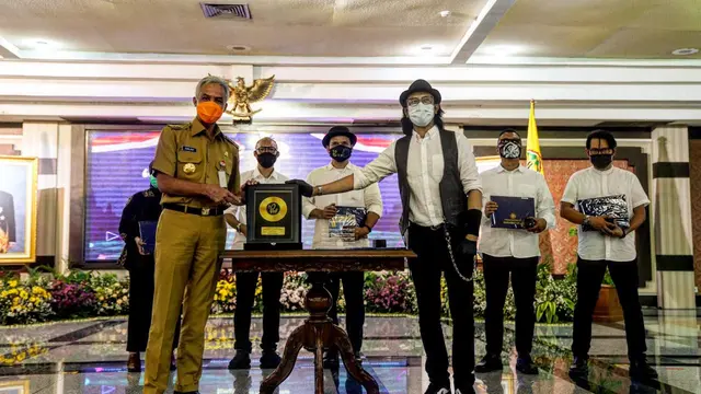 Ketua Umum Kagama, Ganjar Pranowo menerima secara simbolis lagu Kagama Bhakti dari para personil Padi Reborn di Semarang, Jawa Tengah, Senin, 22 Februari 2021.