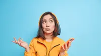 Seorang perempuan berbaju kuning mengangkat kedua tangannya (Foto Dok: Freepik/wayhomestudio).