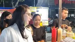 Istri Emil Dardak ini terlihat serius saat mengantre beli telur gulung. Ia terlihat antusias menanti telur gulungnya dibuatkan. Arumi pun dengan bersabar menanti telur gulung yang dipesannya di salah satu lapak di pasar malam. (Liputan6.com/IG/arumibachsin_94)
