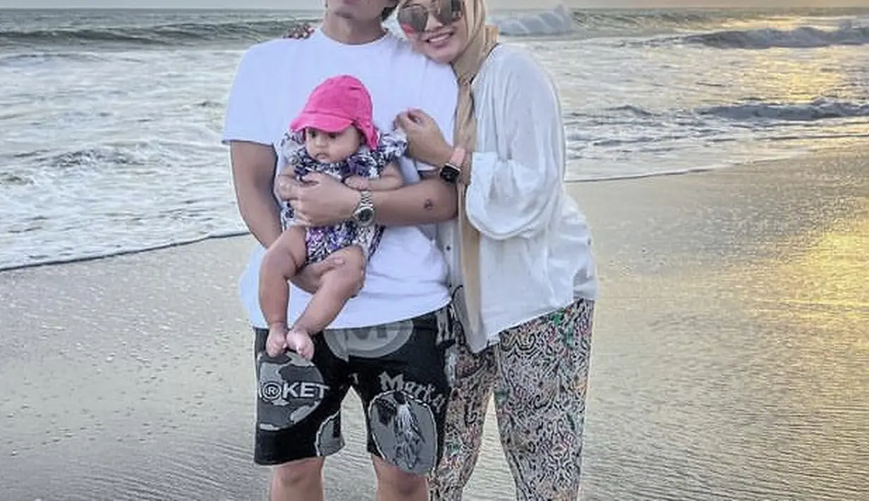 Aurel mengenakan kemeja putih dipadukan celana bermotif dan kerudung coklatnya. @aurelie.hermansyah.