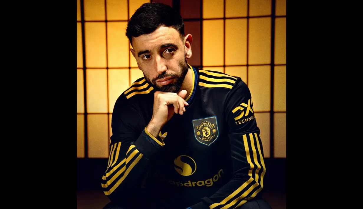 Namun, desainnya tetap mendapat sentuhan pembaruan. Kerah tegak yang dahulu menjadi ciri khas Cantona dihilangkan dan diganti dengan kerah V. (@ManUtd)