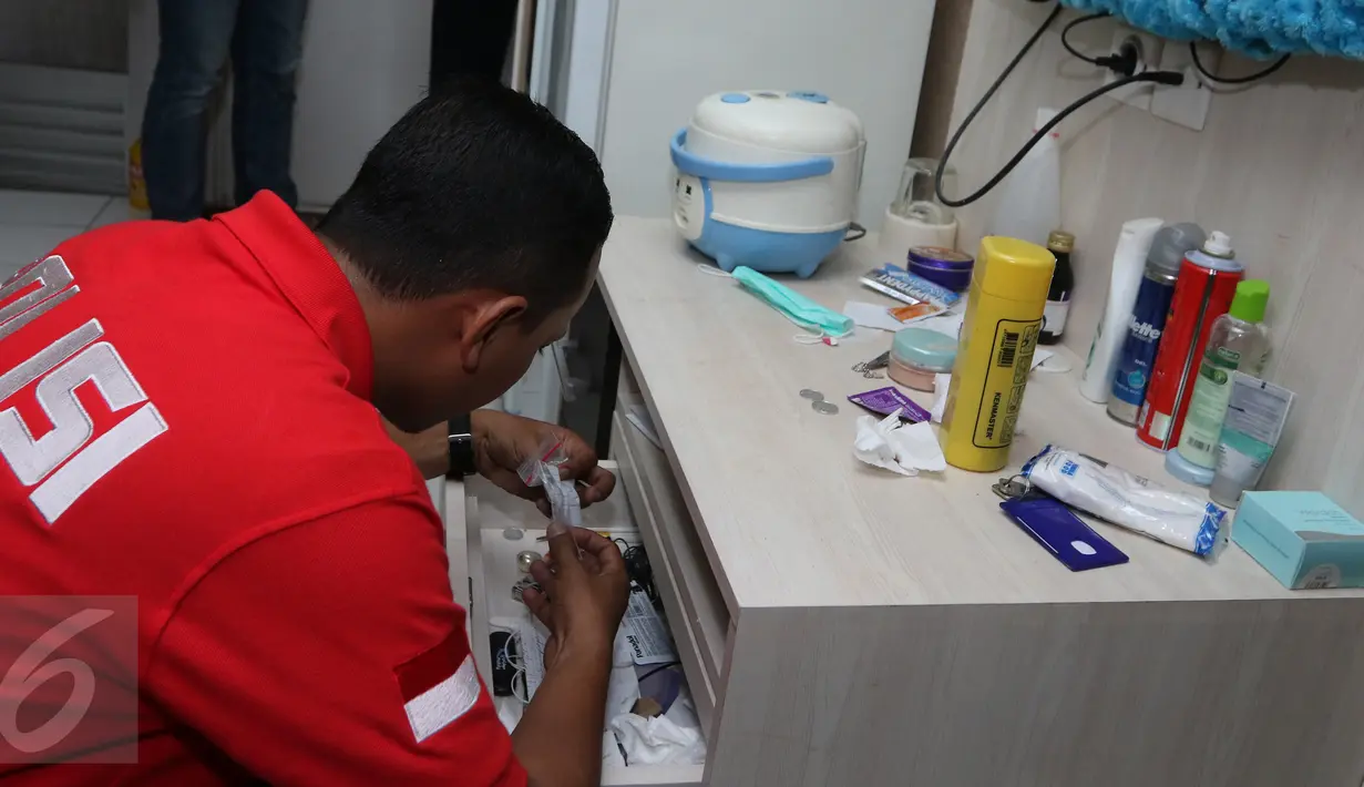Petugas memeriksa salah satu laci milik penghuni kamar saat melakukan razia di Apartemen Kalibata City, Jakarta, Kamis (25/2). Razia digelar dalam rangka mengantisipasi peredaran dan penyalahgunaan narkoba. (Liputan6.com/Herman Zakharia)