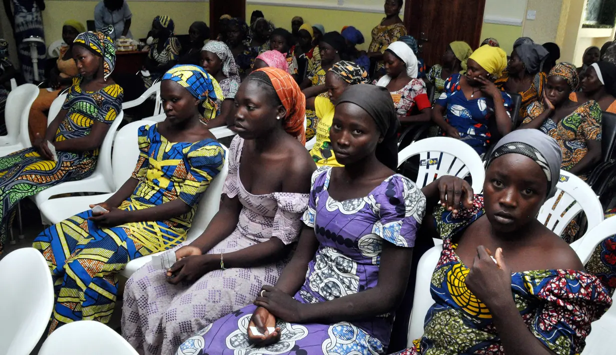 Sejumlah gadis sekolah Chibok menunggu untuk bertemu Presiden Muhammadu Buhari di Abuja, Nigeria (7/5). 82 gadis yang dibebaskan itu ditemukan dekat kota Banki di Negara Bagian Borno, dekat perbatasan dengan Kamerun. (AP Photo/Olamikan Gbemiga)