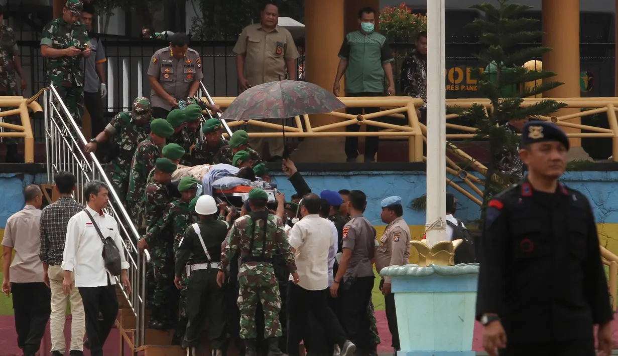 Personel TNI dan polisi membawa Menko Polhukam Wiranto menuju helikopter usai diserang orang tak dikenal di Pandeglang, Banten, Kamis (10/10/2019). Wiranto yang mengalami luka tusuk di bagian perut akibat penyerangan itu dibawa ke RSPAD Gatot Subroto, Jakarta dengan helikopter. (Photo by SAMMY/AFP)