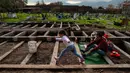 Jose Collantes dan sang putri, Kehity (5) mengunjungi makam istrinya Silvia Cano yang meninggal karena COVID-19 sebulan lalu di Pemakaman Katolik di Santiago, Chili, 5 Agustus 2020. Mereka yang selamat dari pandemi dan yang kehilangan orang yang dicintai, tragedi itu tetap ada. (AP/Esteban Felix)