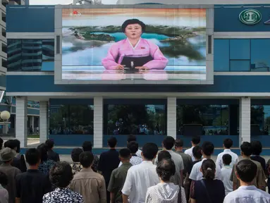  Warga menonton sebuah layar video besar di Mirae Scientists Street di Pyongyang yang menampilkan pembaca berita Ri Chun-Hee saat dia mengumumkan bahwa negara tersebut telah berhasil menguji sebuah bom hidrogen pada Senin (3/9). (AFP Photo/Kim Won-Jin)