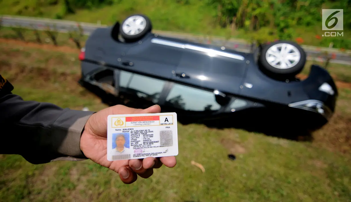Petugas mengevakuasi barang-barang dari mobil Innova yang terbalik di KM 208 Tol Palikanci (Palimanan-Kanci), Jawa Barat, Rabu (21/6). Tidak ada korban jiwa dalam kecelakaan yang diduga karena sopir mobil itu mengantuk. (Liputan6.com/Gempur M Surya)