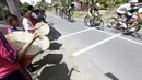 Anak-anak sekolah dasar Sikapak Barat, Pariaman Utara menabuh gendang menyambut pebalap pada etape ke-5 Tour de Singkarak dari Pantai Carocok-Painan menuju pantai Gondoriah-Pariaman, Sumatera Barart. (Bola.com/Nicklas Hanoatubun)