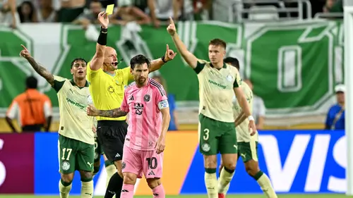 Pemain Inter Miami, Lionel Messi mendapatkan kartu kuning dari wasit setelah melakukan pelanggarang dengan pemain Palmeiras dalam laga Grup A Piala Dunia Antarklub 2025 di Hard Rock stadium, Miami, Amerika Serikat, Selasa (24/06/2025) WIB. (AFP/Patricia De Melo Moreira)