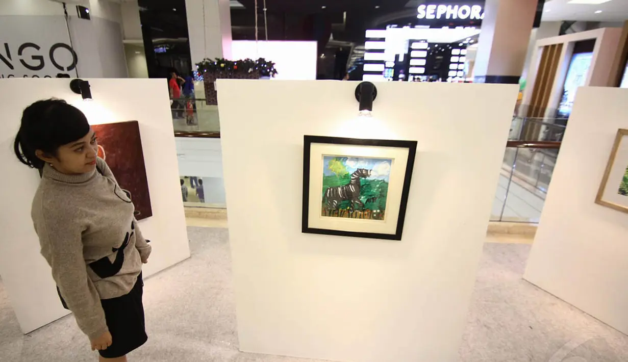 Seorang pengunjung tampak melihat lukisan karya anak penyandang autis di "Jakarta Kids Festival", Minggu (30/11/2014).(Liputan6.com/Faizal Fanani) 