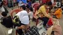 Sejumlah anak mencuci kaki ibu mereka di Kelurahan Duri Pulo, Jakarta, Rabu (21/12/2021). Aksi mencuci kaki ibu secara massal yang diikuti 500 peserta itu bertujuan untuk meningkatkan rasa cinta kasih kepada ibu dan dilakukan dalam rangka memeriahkan Hari Ibu. (Liputan6.com/Herman Zakharia)