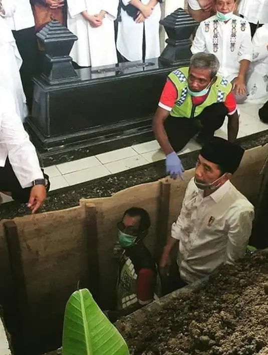 Presiden Joko Widodo atau Jokowi saat berada di liang lahat untuk memakamkan jenazah ibundanya Sudjiatmi Notomihardjo di pemakaman keluarga di Mundu, Kabupaten Karanganyar, Jawa Tengah, Kamis (26/3/2020). Sujiatmi Notomiharjo wafat pada Rabu 25 Maret 2020 pukul 16.45 WIB.  (dok.istimewa)