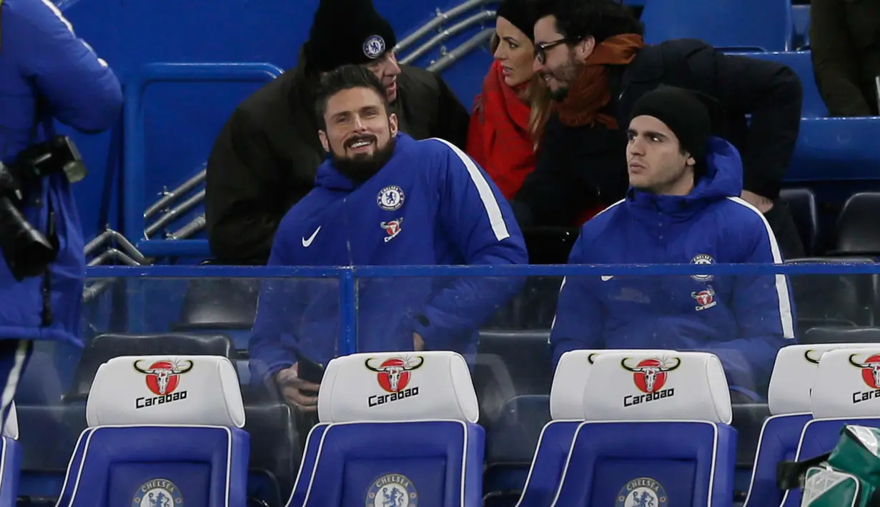 Penyerang baru Chelsea, Olivier Giroud tersenyum saat duduk di bangku cadangan bersama Alvaro Morata saat pertandingan melawan Bournemouth di Stamford Bridge di London, (31/1). Giroud bergabung dengan Chelsea dari Arsenal. (AP Photo / Tim Irlandia)