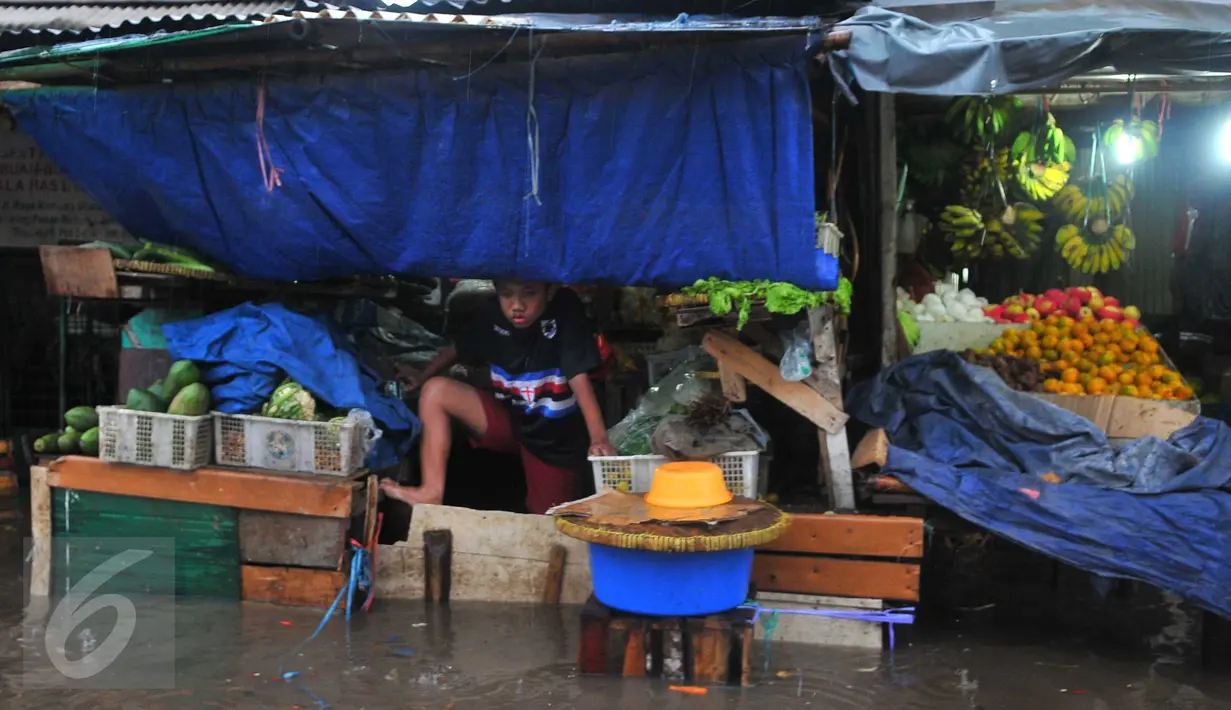 Seorang anak melihat banjir yang melanda kawasan Pasar Buncit, Jakarta Selatan, Selasa (9/2/2016). Banjir menggenangi kawasan tersebut hingga setinggi 100 cm akibat luapan Kali Kemang. (Liputan6.com/Gempur M Surya)