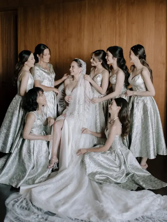 Berbeda dari akad, kali ini mereka tampil kompak mengenakan silk dress nuansa broken white dari @soecah_bridesmaid. [Foto: IG/enzystoria].