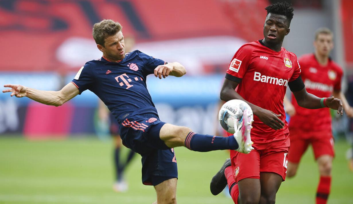 Striker Bayern Munchen, Thomas Mueller, melepaskan tendangan saat melawan Bayer Leverkusen pada laga Bundesliga di BayArena, Sabtu (6/6/2020). Bayern Munchen menang 4-2 atas Bayer Leverkusen. (AP/Matthias Hangst)