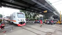 Kereta melintas di perlintasan kereta api di kawasan Roxy, Jakarta, Rabu (21/3). Petugas Sudinhub Jakpus telah menutup akses perlintasan KA di depan Roxy 20 September 2017, namun mendapat protes keras dari warga.  (Liputan6.com/Arya Manggala)
