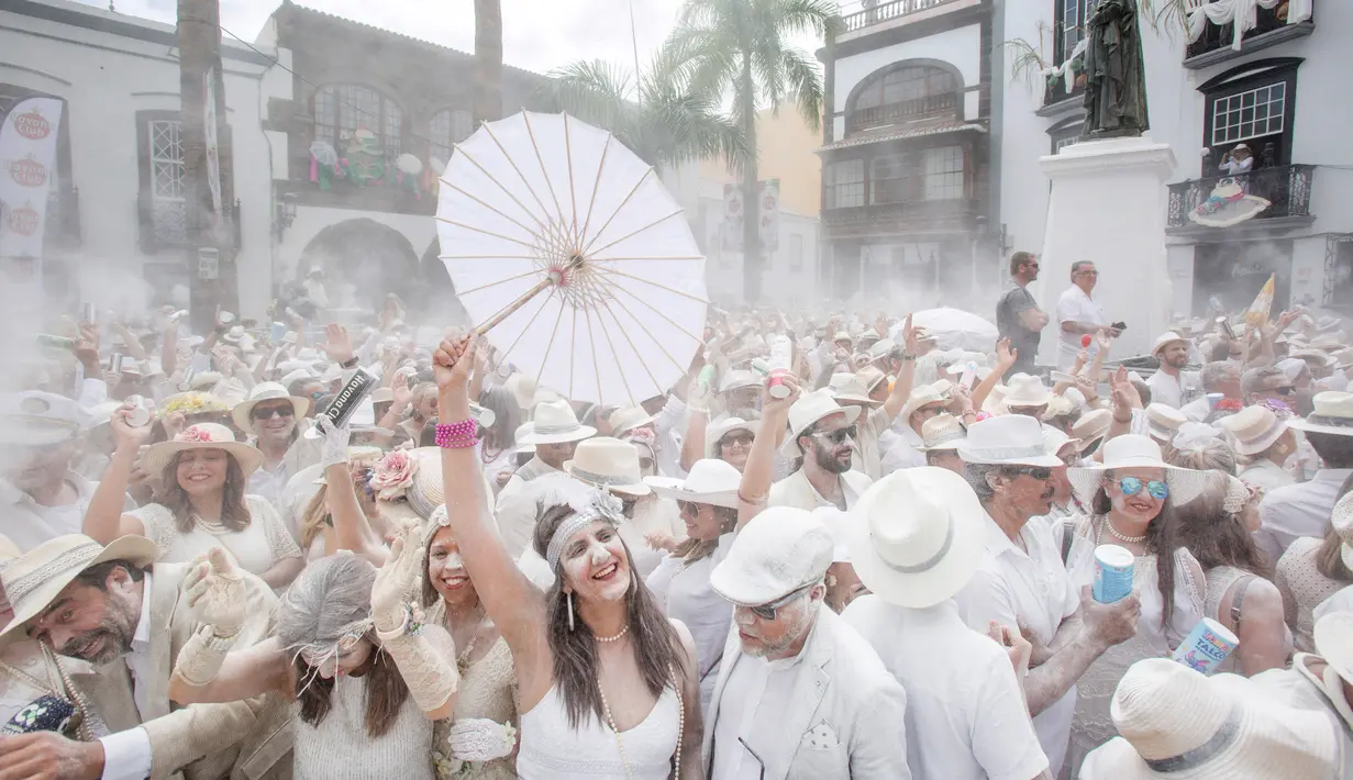 Orang-orang bersuka ria dengan berselimut bedak saat karnaval jalanan 'Los Indianos' di Santa Cruz de la Palma, Spanyol, Senin (4/3). Untuk ambil bagian di Los Indianos, mereka harus memakai pakaian putih dari ujung kepala hingga kaki (DESIREE MARTIN/AFP)