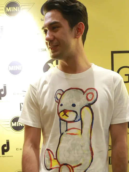 Jika biasanya Reza Rahadian kerap terlihat dalam balutan busana formal, ia juga senang tampil santai dan casual dengan kaos. Kali ini sang aktor memilih kaos dengan gambar karakter kesukaan anak-anak, Teddy Bear. (Galih W. Satria/Bintang.com)